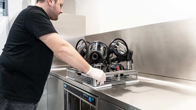 SCBA technician inserts pre-cleaned PPE into the TopClean M SCBA technician inserts pre-cleaned PPE into the TopClean M