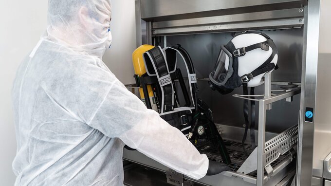 An SCBA technician loads the pre-cleaning washer TopCleanTopClean D with PPE An SCBA technician loads the pre-cleaning washer TopCleanTopClean D with PPE